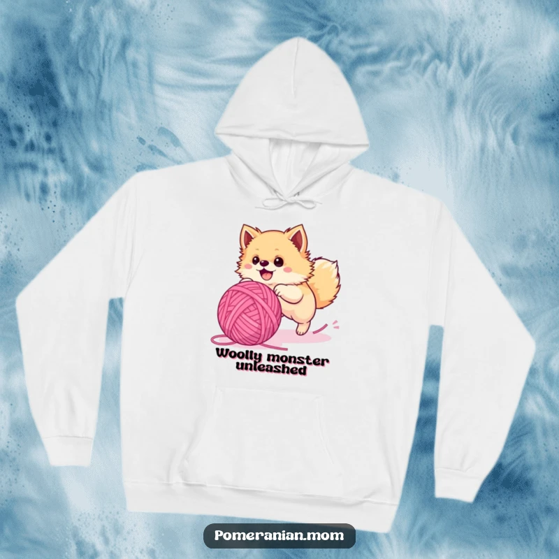 Funny Pomeranian hoodie, a fluffy dog with wide eyes chasing a huge ball of yarn, highlighting its playful and determined nature.