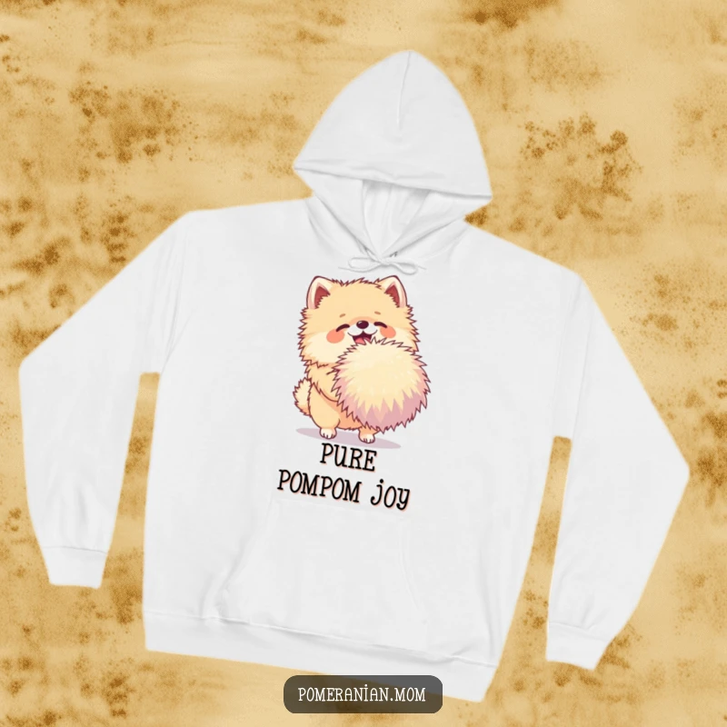 Funny Pomeranian hoodie showing a joyful dog shaking a very large pom-pom, providing warmth and playful charm.
