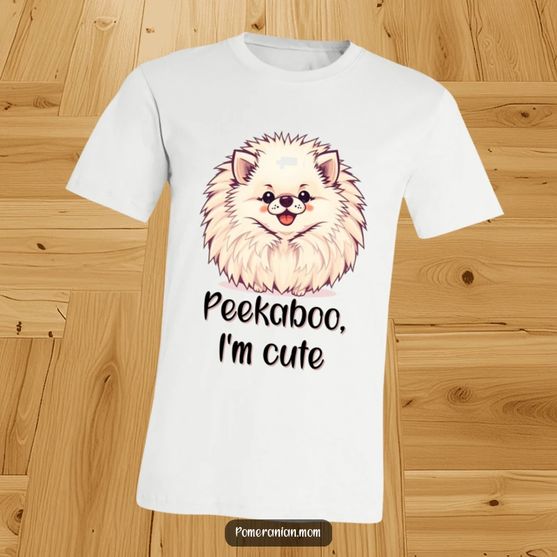 Funny Pomeranian T-Shirt with a happy Pomeranian peeking from behind a big, cheerful pompom.
